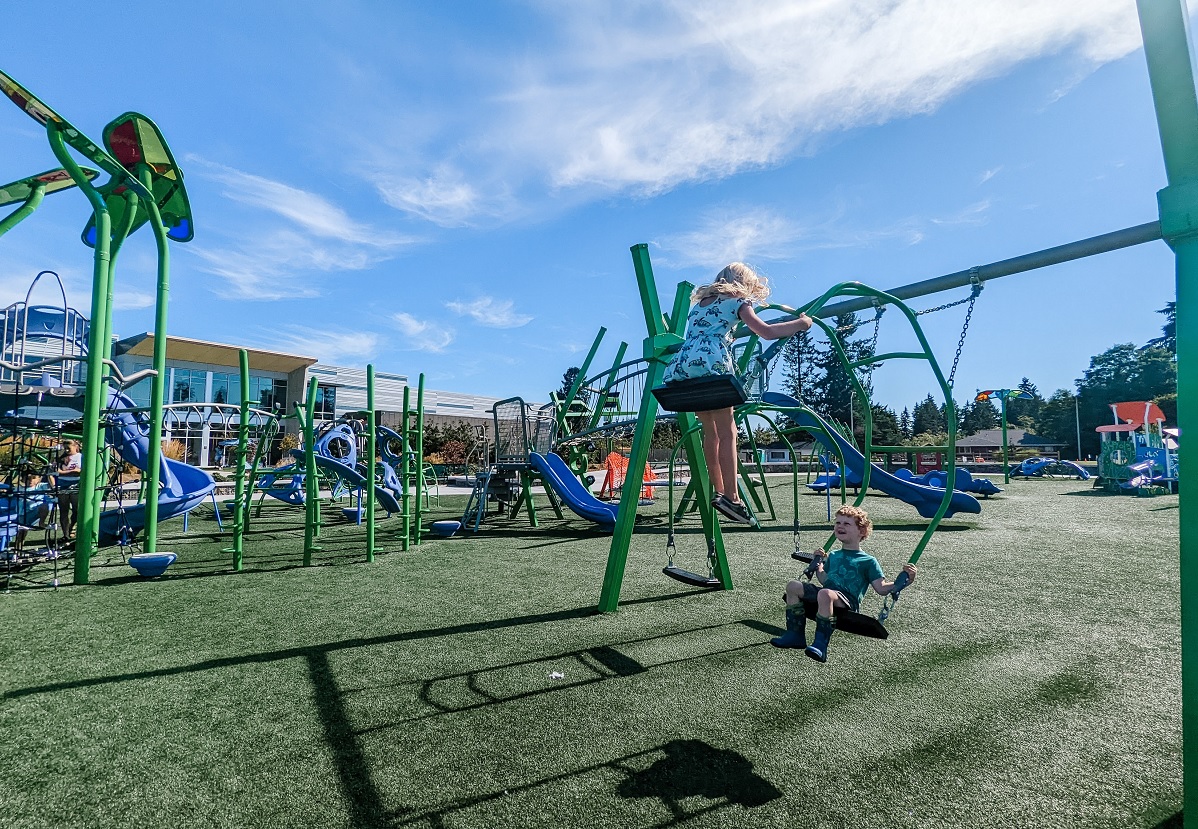 Kids on swings at new Emma Yule Park playground in Everett
